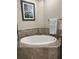 Soaking tub with tile surround, next to walk-in shower, with nature art on the wall at 3418 79Th Street W Cir # 202, Bradenton, FL 34209