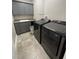 Laundry room featuring gray cabinets, granite countertop, and modern washer and dryer units at 3418 79Th Street W Cir # 202, Bradenton, FL 34209