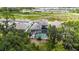 An aerial view features a home with a screened-in pool within a community and a scenic backdrop at 3553 Secluded Ct, Sarasota, FL 34240