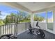Covered balcony with gym equipment overlooking treetops and greenery at 3553 Secluded Ct, Sarasota, FL 34240