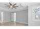 Bedroom with a ceiling fan, tray ceiling, and plantation shutters on the windows at 3553 Secluded Ct, Sarasota, FL 34240