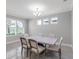 Bright dining room with a modern chandelier, three sunny windows, and a large formal dining table at 3553 Secluded Ct, Sarasota, FL 34240