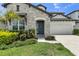 Elegant front entrance featuring a stone facade, well-manicured landscaping, and a lush green lawn at 3553 Secluded Ct, Sarasota, FL 34240