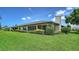 Manicured backyard with green grass, garden beds, and white home exterior at 3734 Ballantrae Dr # 19D, Sarasota, FL 34238