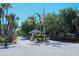 Entrance to community with guard house, mature trees, and American flag at 3734 Ballantrae Dr # 19D, Sarasota, FL 34238