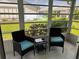 Bright sunroom featuring two wicker chairs with blue cushions and a glass table, offering serene views of the outdoors at 3703 39Th Street W # 11, Bradenton, FL 34205