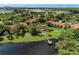 Aerial view of community featuring multiple buildings, lush landscaping, a lake, and a dock at 4057 Crockers Lake Blvd # 15, Sarasota, FL 34238
