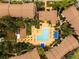 Aerial view of a community pool area with a clear blue pool, lounge chairs, and lush landscaping at 4057 Crockers Lake Blvd # 15, Sarasota, FL 34238