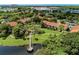 Aerial view of community featuring multiple buildings, lush landscaping, a lake, and a dock at 4057 Crockers Lake Blvd # 15, Sarasota, FL 34238