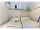 Bright laundry room with a washing machine, a dryer, and an overhead storage shelf at 4057 Crockers Lake Blvd # 15, Sarasota, FL 34238