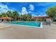 Inviting community pool surrounded by lush landscaping, lounge chairs, and a well-maintained deck under a sunny sky at 4057 Crockers Lake Blvd # 15, Sarasota, FL 34238
