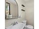 Cozy bathroom with a pedestal sink, a unique mirror, and neutral wall colors at 412 E Amelia Ave, Tampa, FL 33602