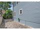 Exterior side view with brick pavers, lush landscaping, and garden hose at 412 E Amelia Ave, Tampa, FL 33602
