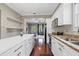 A kitchen showcasing white cabinets, stainless appliances, and seamless flow to the living space at 412 E Amelia Ave, Tampa, FL 33602