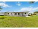 View of the home's exterior back elevation with an expansive lawn at 417 Glen Oak Rd, Venice, FL 34293