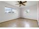 Bedroom features neutral walls, tile flooring, a ceiling fan, and two windows at 417 Glen Oak Rd, Venice, FL 34293
