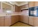 Kitchen featuring ample wood cabinets, appliances and window looking to the outside of the house at 417 Glen Oak Rd, Venice, FL 34293