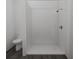Modern bathroom features a walk-in shower with glass enclosure, white walls, dark floors, and a toilet at 4515 Boxelder Avenue, Parrish, FL 34219