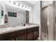 Bathroom with double sinks, a large mirror, and a tiled shower at 4644 Vignette Way, Sarasota, FL 34240