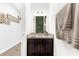 Well-lit powder room with dark vanity, granite countertop, and decorative wall art in neutral tones at 4644 Vignette Way, Sarasota, FL 34240