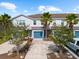 Charming townhouse with well-maintained landscaping, blue garage door, and palm trees in a sunny neighborhood at 4644 Vignette Way, Sarasota, FL 34240