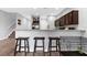 Kitchen with breakfast bar, dark cabinets, stainless appliances, and view of the staircase at 4644 Vignette Way, Sarasota, FL 34240