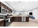 Spacious kitchen with stainless steel appliances, dark cabinets, and an open view into the living area at 4644 Vignette Way, Sarasota, FL 34240