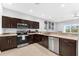 Updated kitchen featuring stainless steel appliances, dark cabinets, and a view of the backyard at 4644 Vignette Way, Sarasota, FL 34240