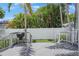 Backyard features a gray wood deck, grill, palm trees, and white fencing at 480 28Th N Ave, St Petersburg, FL 33704