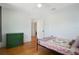 Bright bedroom with hardwood floors, green dresser, and quilt-covered bed at 480 28Th N Ave, St Petersburg, FL 33704