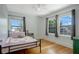 Cozy bedroom with hardwood floors, a comfy bed, and two windows for ample natural light at 480 28Th N Ave, St Petersburg, FL 33704