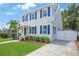 Inviting two-story home featuring lush greenery, complemented by a spacious driveway and crisp white fencing at 480 28Th N Ave, St Petersburg, FL 33704