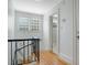 Bright hallway with wood floors, a glass block window and blue bannister leads to the upper level at 480 28Th N Ave, St Petersburg, FL 33704