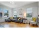 Bright living room featuring a gray sectional, hardwood floors, and natural light from large windows at 480 28Th N Ave, St Petersburg, FL 33704