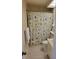 Clean bathroom with a floral shower curtain, neutral walls, and white fixtures at 4835 Winslow Beacon # 46, Sarasota, FL 34235