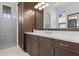 Modern bathroom features dark wood cabinets, dual sinks, white countertops, and a glass-enclosed shower at 4931 Benito Ct, Bradenton, FL 34211