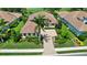 Beautifully landscaped home with a paver driveway, mature palm trees, and lush green lawns near the golf course at 4931 Benito Ct, Bradenton, FL 34211
