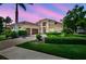 Beautiful exterior elevation of a modern two-story home with lush landscaping at dusk at 4931 Benito Ct, Bradenton, FL 34211