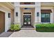 Elegant front entry featuring stone pavers, manicured landscaping, and double doors at 4931 Benito Ct, Bradenton, FL 34211