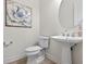 Clean powder room with pedestal sink, wood floors and decorative mirror at 4931 Benito Ct, Bradenton, FL 34211