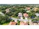 Overhead view showcases the home's tile roof and neighborhood's mature trees near a lake, creating a serene setting at 5018 Hanging Moss Ln, Sarasota, FL 34238