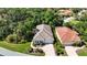 Aerial view of a home with lush landscaping, paved driveway, and a neutral-toned tile roof at 5018 Hanging Moss Ln, Sarasota, FL 34238