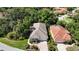 Aerial shot of a single-story residence with a tile roof, surrounded by mature trees and landscaping in a residential neighborhood at 5018 Hanging Moss Ln, Sarasota, FL 34238