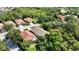 Aerial view of property surrounded by lush greenery, highlighting tile roofs and well-maintained landscaping in a residential area at 5018 Hanging Moss Ln, Sarasota, FL 34238