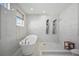 Elegant bathroom boasting soaking tub, walk-in shower with dual shower heads, and marble tiling at 5018 Hanging Moss Ln, Sarasota, FL 34238