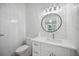 Elegant half-bathroom with marbled wall, decorative lighting, and modern sink and toilet at 5018 Hanging Moss Ln, Sarasota, FL 34238
