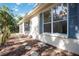 Charming exterior with stone pathway and blue shutters, complemented by lush foliage for added privacy at 5018 Hanging Moss Ln, Sarasota, FL 34238