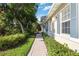 Charming home exterior with lush landscaping along a paver walkway and beautiful lush trees and plantings at 5018 Hanging Moss Ln, Sarasota, FL 34238