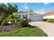 Inviting home with a tile roof, two-car garage, and a patterned paver driveway surrounded by lush landscaping at 5018 Hanging Moss Ln, Sarasota, FL 34238