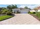 Charming single story home featuring manicured landscaping and a patterned paver driveway leading to a two car garage at 5018 Hanging Moss Ln, Sarasota, FL 34238